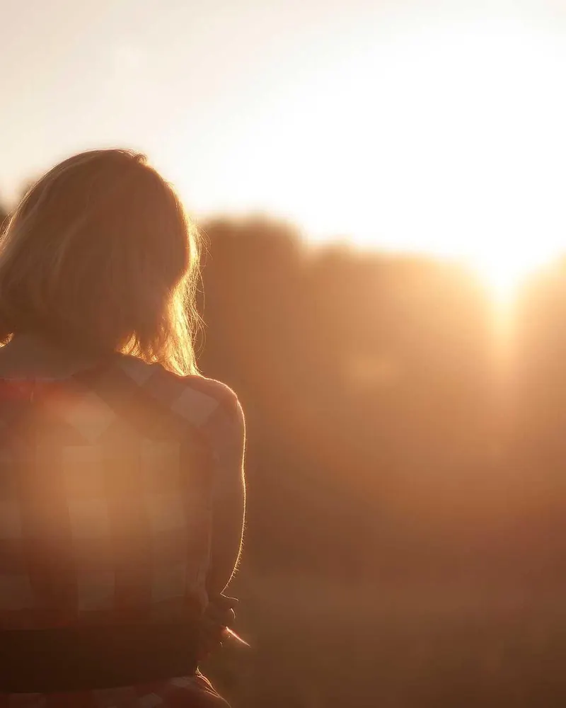 Retrato em contraluz com o sol atrás das árvores